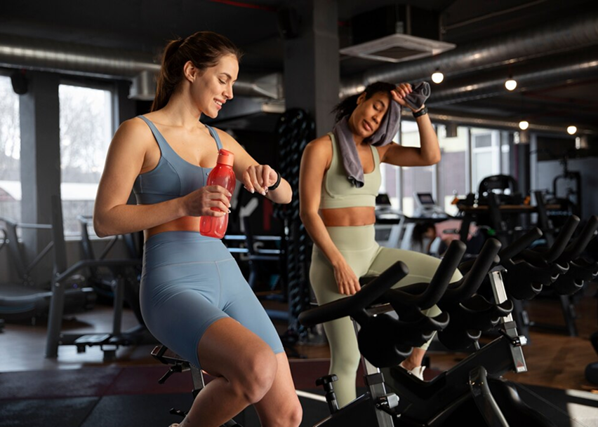 Девушки тренируются на велотренажере